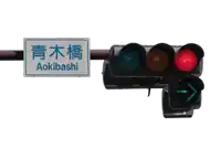 a traffic light with a sign that says aokibashi on it