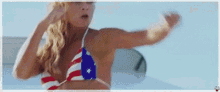 a woman in a bikini with an american flag on it is dancing .