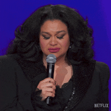 a woman holding a microphone with netflix written on the bottom