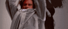 a man is wrapped in a white cloth and has a red face