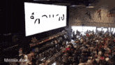 a crowd of people are gathered in front of a large screen that says ' memix.com '