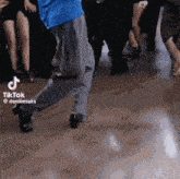 a man in a blue shirt is dancing in front of a crowd on a dance floor .