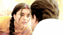 a man and a woman are looking at each other and the woman has a red dot on her forehead