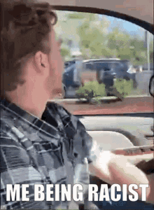 a man in a plaid shirt is driving a car and says " me being racist " at the bottom