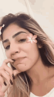 a woman with a flower on her face is talking on a phone
