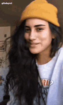 a girl wearing a yellow beanie and a trap shirt
