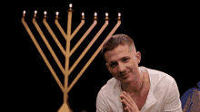 a man stands in front of a menorah with candles on it