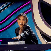 a woman is sitting in front of a rbd3d television