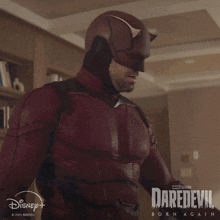 a man in a daredevil costume is standing in a living room