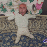 a doll with a bald head is laying on a bed