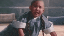 a little boy is sitting on the floor crying .
