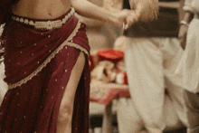 a woman in a red skirt is dancing in front of a man