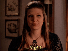 a woman wearing a black lace top and a necklace says right