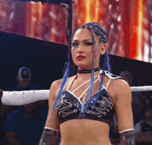 a woman with blue braids is standing in a ring