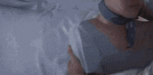 a woman is laying in a hospital bed with her eyes closed and a man is hugging her .