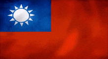 a blue , red and white flag with a white sun on it is waving in the wind .
