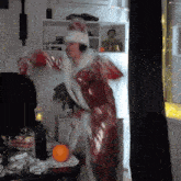 a man in a santa claus costume is dancing in a living room in front of a window .