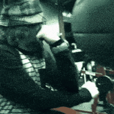 a man with a beard wearing a hat is sitting at a desk