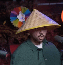 a man wearing a conical hat with a flower on top