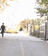 a woman is walking down a street with a bag in her hand .