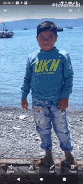 a boy wearing a blue shirt that says ukn