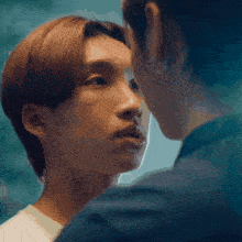 a close up of two men looking at each other 's faces