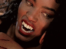 a close up of a woman 's face with her mouth open
