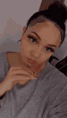 a woman is taking a selfie with a bun in her hair