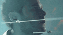 a close up of a man 's face with a string coming out of his nose