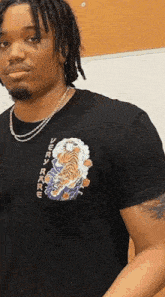 a man wearing a black t-shirt with a tiger on the front