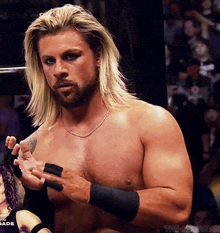 a man with long blonde hair and a beard is standing in front of a crowd