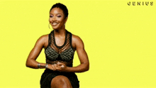 a woman in a black dress is sitting on a yellow background with the word genius written on it