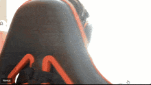 a person sitting in a chair with the word nomus on the bottom right