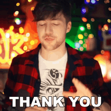 a man in a plaid shirt is saying thank you with his eyes closed