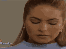 a close up of a woman 's face with the words tinovelas on the bottom right