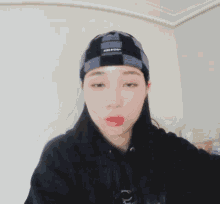 a girl wearing a black hoodie and a plaid beanie has a question mark above her head