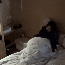 a woman is laying on a bed in a dark room