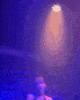 a woman is taking a selfie in front of a purple background .