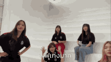a group of girls are posing for a picture and one of them is wearing a black shirt that says a on it