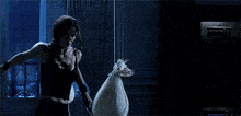 a woman in a black tank top is holding a bag in her hand