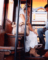 a woman in a white dress is sitting on a bench
