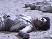a person laying in the sand with the words & team e on the bottom