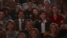 a crowd of people sitting in a stadium watching a presentation