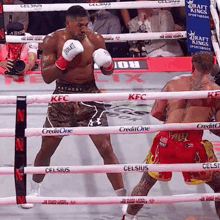 two boxers are fighting in a ring with celsius ropes