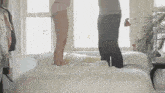 a man and a woman are jumping on a bed in a bedroom