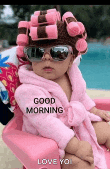 a baby with curlers on her head and sunglasses is sitting in a pink chair .