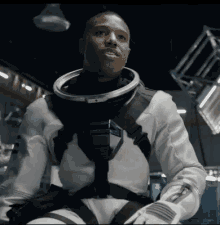 a man in an astronaut 's suit is sitting in a room .
