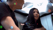 a man and a woman are standing next to each other with tayo written on the bottom right