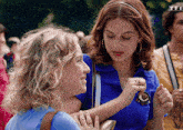 two women are standing next to each other with a tfi logo on the bottom right
