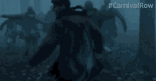 a group of people are running through a foggy forest with #carnivalrow written above them